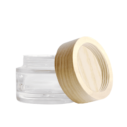 Wood cap leaning on round clear glass jar